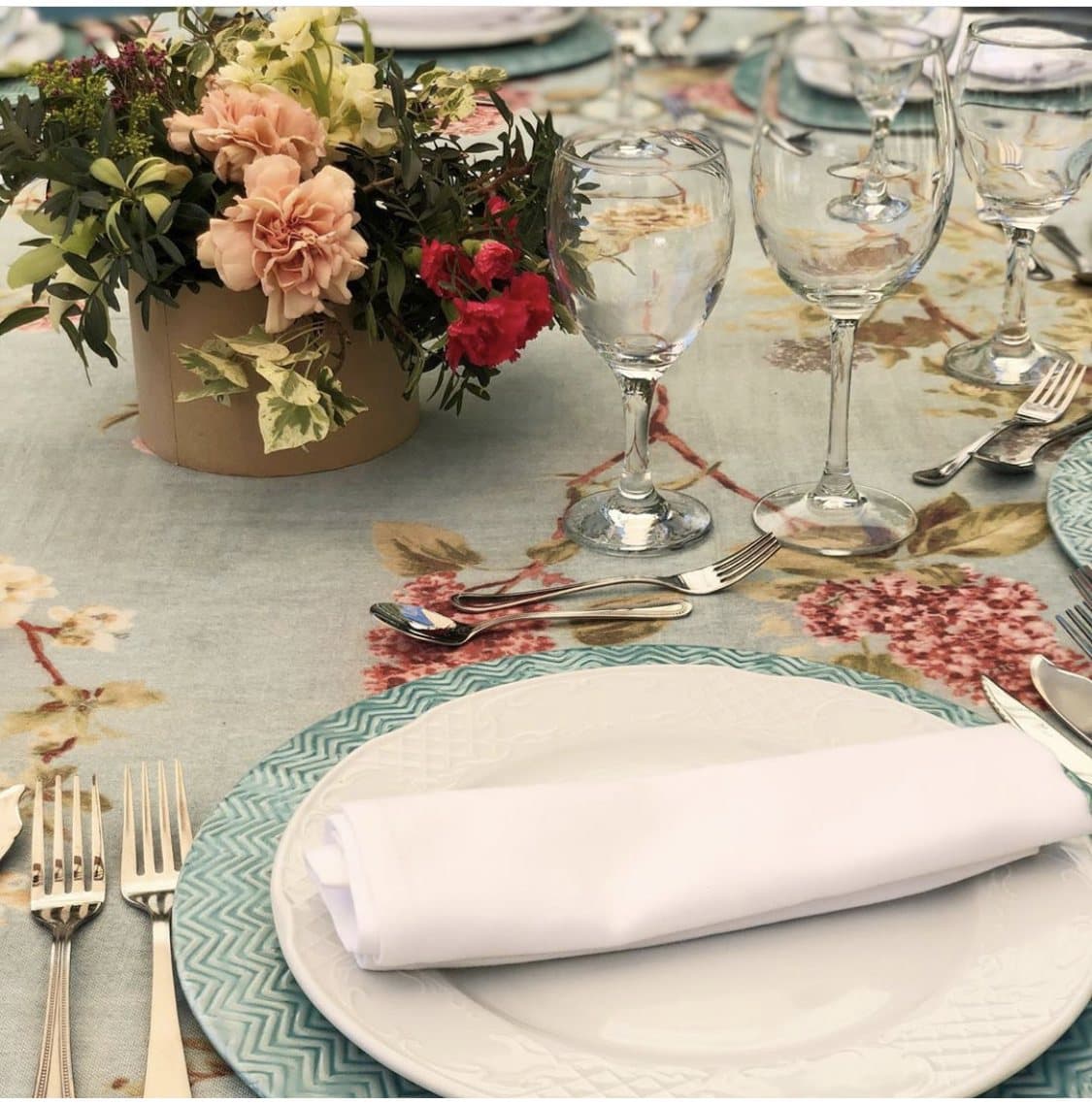 Mesa de catering en Madrid con cristaleria y arreglo floral sobre mantel editorial