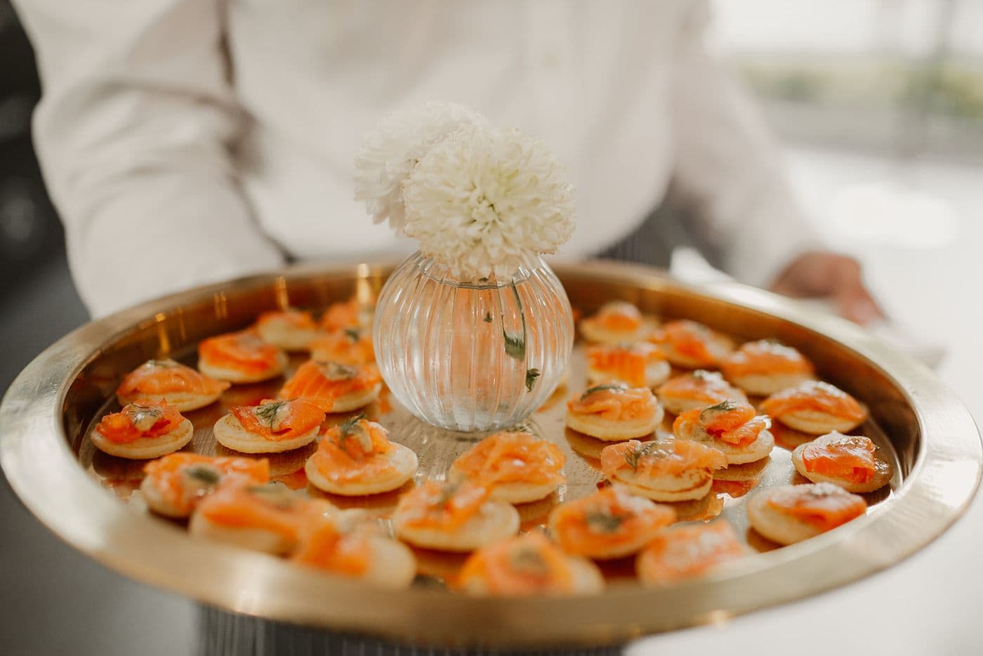 Canapes de salmon en bandeja dorada para catering premium en Madrid